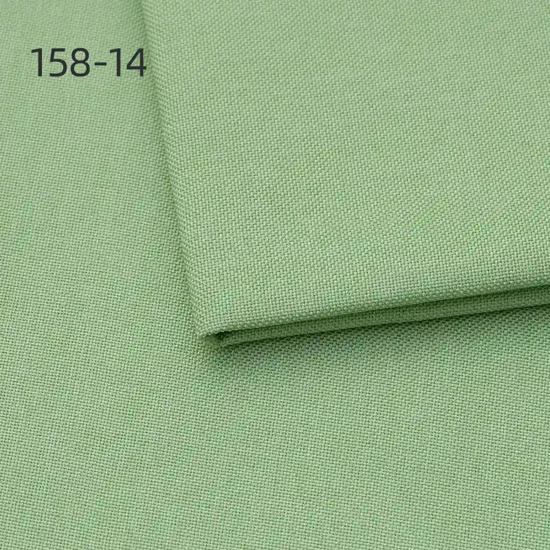 A close-up of Longan Craft Faux Linen Upholstery Fabric By The Yard in light green polyester shows a folded piece on top, with "158-14" in the upper left corner. Perfect for upholstering furniture, reupholstering chairs, sofas, or curtains.