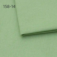 A close-up of Longan Craft Faux Linen Upholstery Fabric By The Yard in light green polyester shows a folded piece on top, with "158-14" in the upper left corner. Perfect for upholstering furniture, reupholstering chairs, sofas, or curtains.