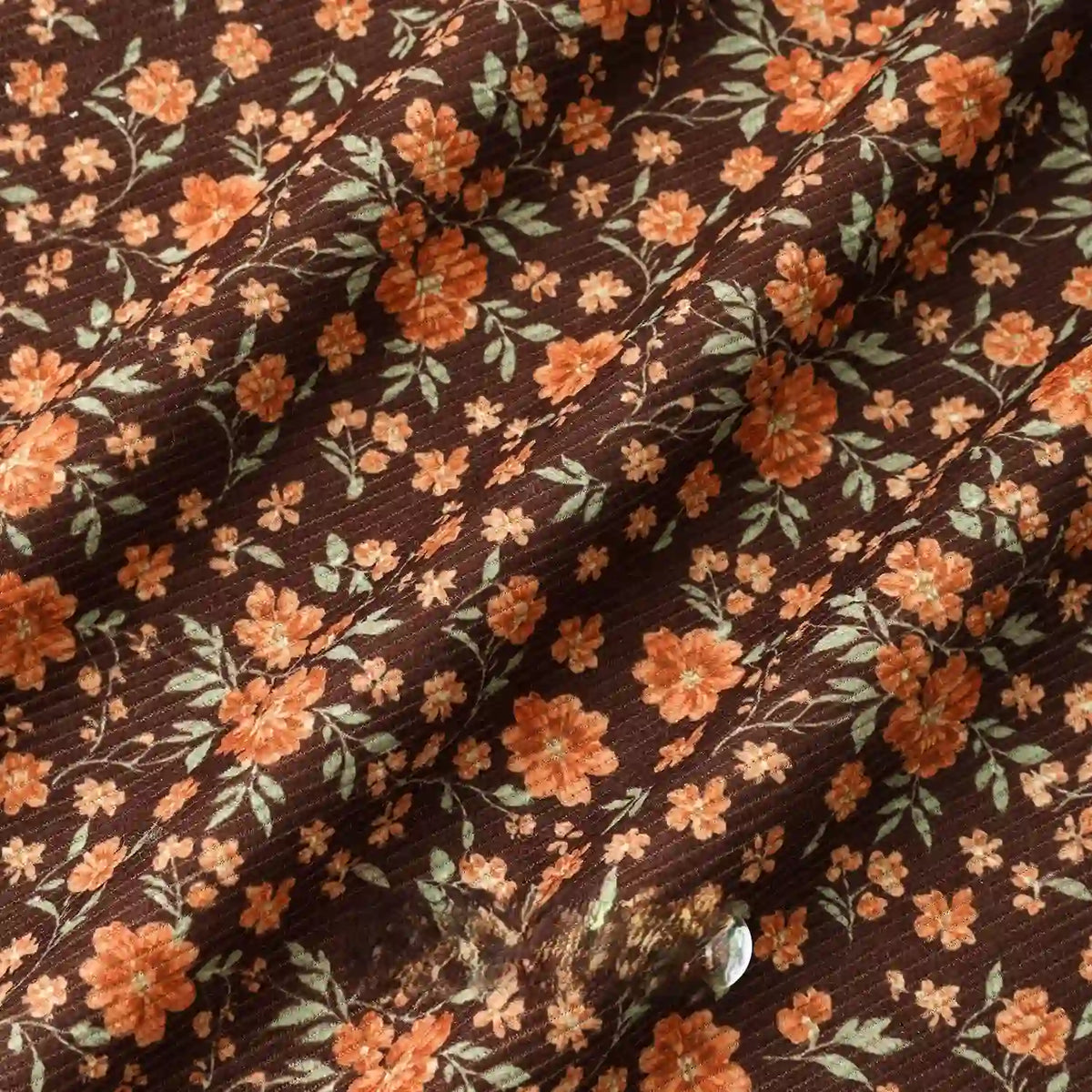 Longan Craft 16 Wale Floral Printed Corduroy Fabric By The Yard features colorful orange and yellow flowers with green leaves on fine ribbed corduroy, offering a soft drape and gentle texture—ideal for casual wear and creative projects.