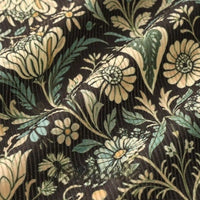 Close-up of Longan Craft 16 Wale Floral Printed Corduroy Fabric by the yard, featuring cream and light green flowers on a dark background. This premium, colorful fine wale textile is perfect for casual wear with its elegant printed pattern.