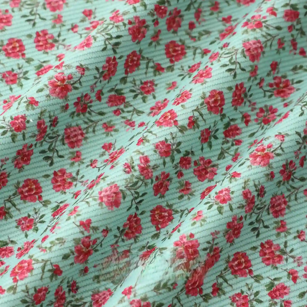 Longan Craft’s 16 Wale Floral Printed Corduroy Fabric By The Yard features a colorful fine wale corduroy with small red and pink flowers on a light blue, ribbed surface—premium corduroy textile ideal for casual wear.