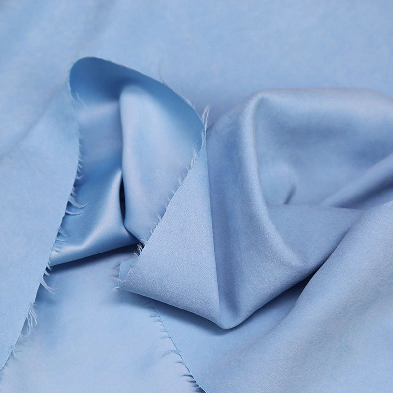 A close-up of Longan Craft Multi Color Microsuede Polyester Peachskin Fabric By The Yard shows its soft, brushed texture, gentle folds, and slightly frayed edges—perfect cozy peachskin material for clothing.