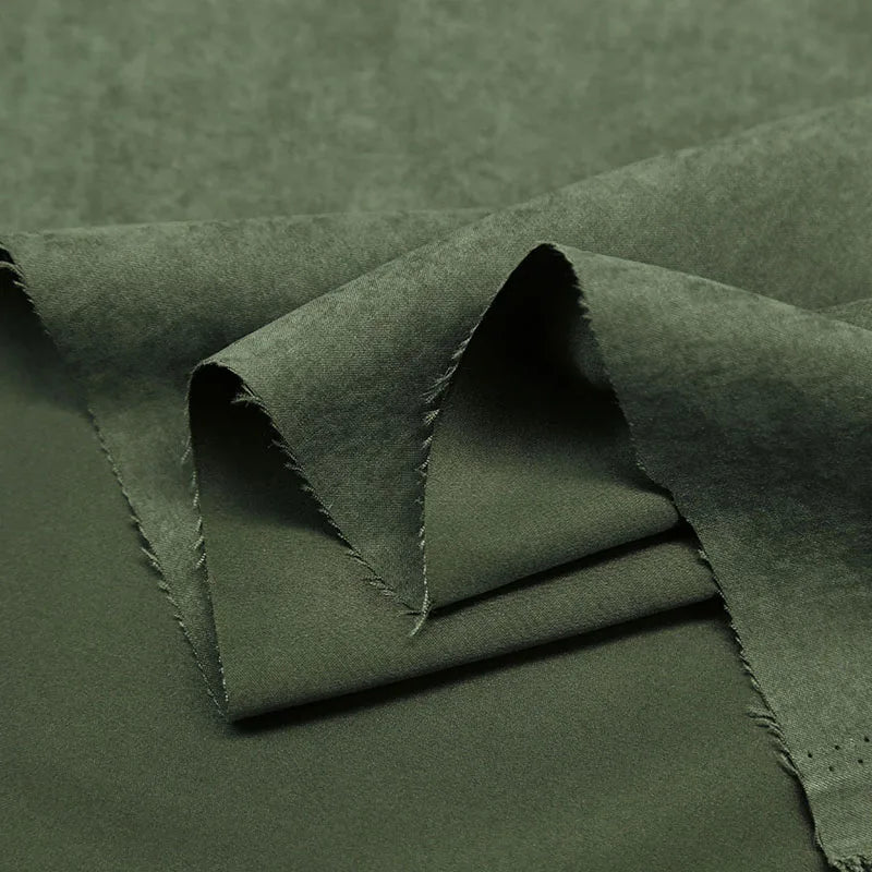 A close-up of Longan Craft’s Multi Color Microsuede Polyester Peachskin Fabric shows its soft, brushed peach skin texture with layered, slightly frayed edges—ideal for cozy clothing by the yard.