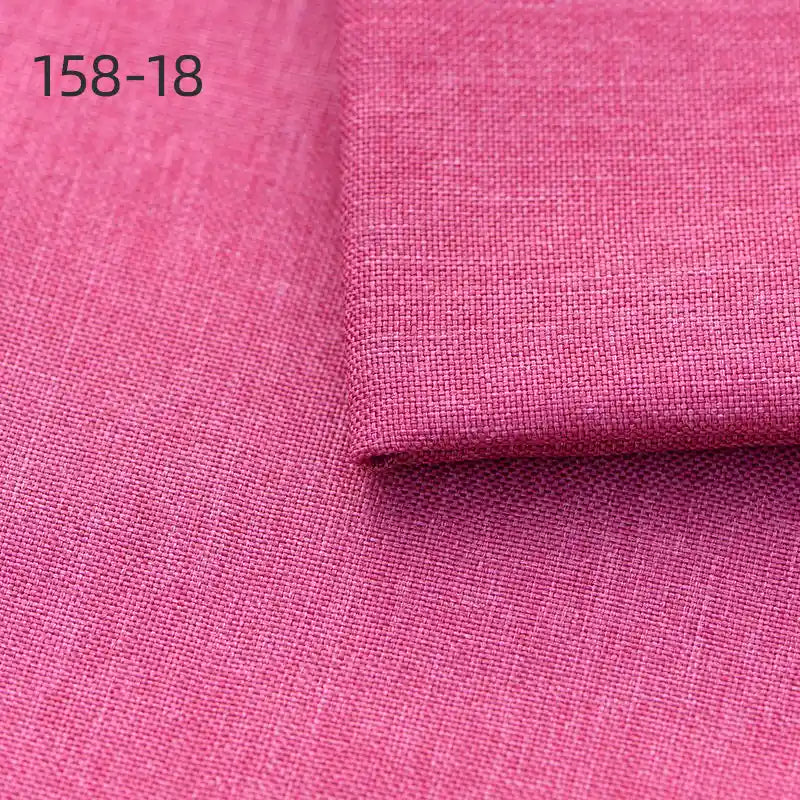 Close-up of textured pink Longan Craft Faux Linen Upholstery Fabric, made of polyester for chairs, sofas, or curtains, with a folded corner and "158-18" labeled in black on the upper left.