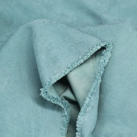 Close-up of folded Multi Color Microsuede Polyester Peachskin Fabric by the yard from Longan Craft, showing its soft, brushed peach skin texture and slightly frayed edge—ideal cozy material for clothing.