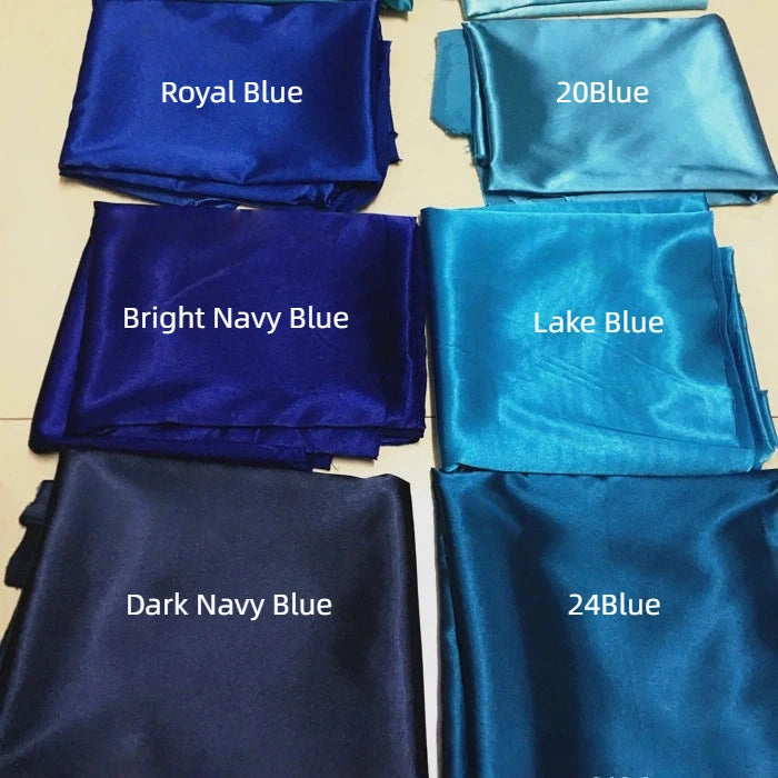 Six folded pieces of Longan Craft Solid Color Polyester Satin Fabric By The Yard in various blue shades—Royal Blue, 20Blue, Bright Navy Blue, Lake Blue, Dark Navy Blue, and 24Blue—highlight its silky stretch texture and elegant sheen.