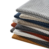A neatly stacked pile of Longan Craft's 2.5 Wale Multicolor Polyester Corduroy Fabric by the yard—perfect for upholstery projects—in shades like grey, beige, blue, brown, mustard, and white arranged in alternating layers.