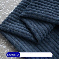 A close-up of folded, dark blue 2.5 Wale Corduroy Fabric By The Yard from Longan Craft rests on a terrazzo surface. A white and blue label at the bottom displays the code “SY1078-14.”.