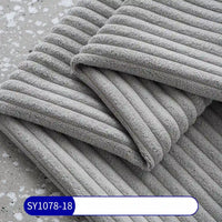 A close-up of neatly folded gray towels made from Longan Craft's 2.5 Wale Corduroy Fabric By The Yard, a multicolor polyester corduroy upholstery material. A label at the bottom shows "SY1078-18" in white text on blue.