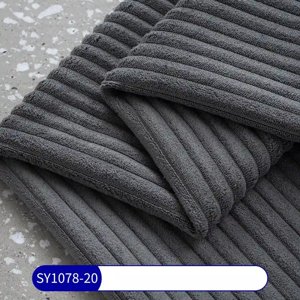 Two folded, dark gray towels resembling Longan Craft's 2.5 Wale Corduroy Fabric By The Yard are stacked on a speckled surface. A white label with blue border and text SY1078-20 is visible at the bottom.