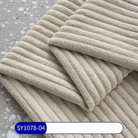 Folded beige towels, evoking 2.5 wale corduroy, rest on a grey speckled surface. The Longan Craft 2.5 Wale Corduroy Fabric By The Yard (SY1078-04) is labeled in blue and white at the bottom of the image.