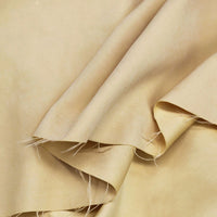 A close-up of Longan Craft Multi Color Microsuede Polyester Peachskin Fabric shows its smooth brushed texture, unfinished frayed edges, and gentle folds—cozy material perfect for clothing by the yard.