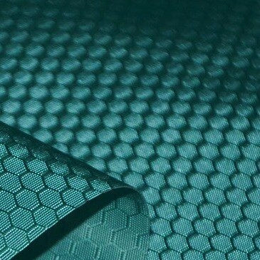 A close-up of Longan Craft’s 210D Honeycomb Pattern Oxford Fabric by the yard shows its colorful hexagonal PU-coated, waterproof polyester surface—flexible and ideal for outdoor use, with one corner lifted to display texture.