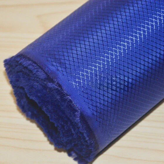 A close-up of Longan Craft’s 210D Honeycomb Pattern Oxford Fabric By The Yard, featuring a visible diamond grid on blue waterproof PU-coated material—ideal for outdoor use and gear.