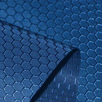 A close-up of Longan Craft's 210D Honeycomb Pattern Oxford Fabric By The Yard featuring a repeating hexagonal design. This colorful PU-coated, waterproof fabric is partly rolled at the corner, ideal for outdoor use.