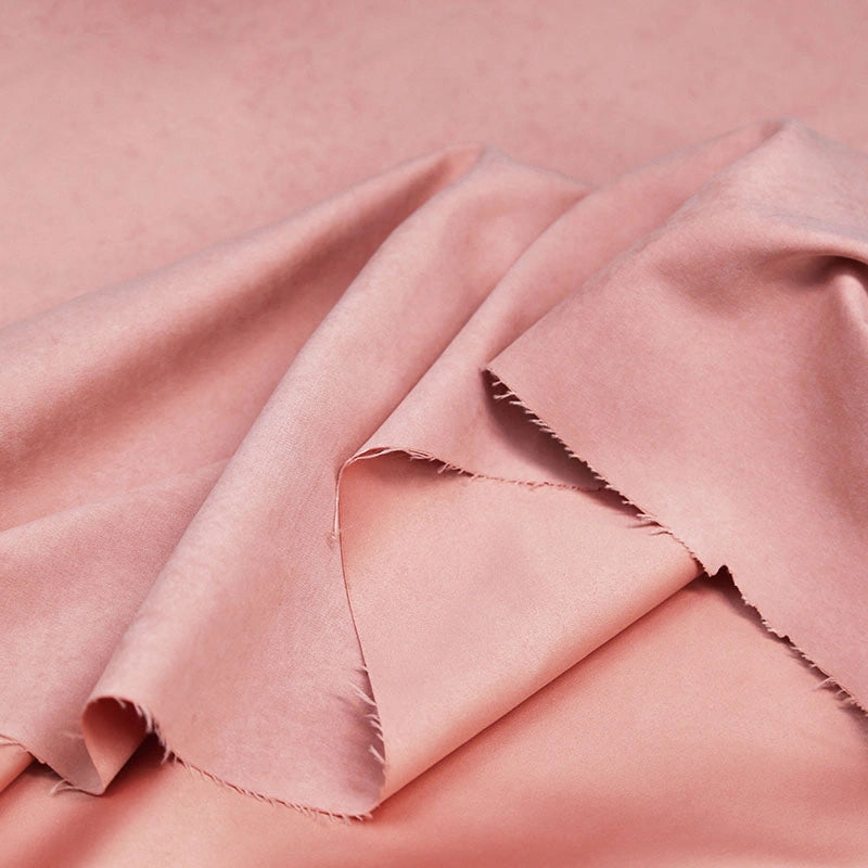 A close-up of Longan Craft’s Multi Color Microsuede Polyester Peachskin Fabric By The Yard, featuring a soft, brushed peach skin texture with gentle folds and unfinished edges—ideal cozy material for clothing.