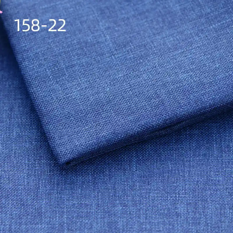 Folded and flat pieces of Longan Craft Faux Linen Upholstery Fabric are displayed in blue with a subtle textured weave. Labeled 158-22 in white text, this polyester fabric is ideal for upholstering chairs, sofas, or curtains.