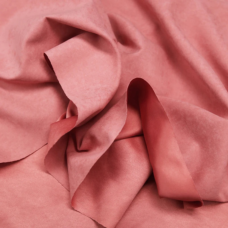 A close-up of Longan Craft Multi Color Microsuede Polyester Peachskin Fabric By The Yard reveals its brushed peach skin texture and gentle folds, highlighting the cozy, velvety material ideal for clothing.