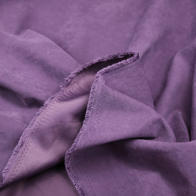 A close-up of Longan Craft’s Multi Color Microsuede Polyester Peachskin Fabric, showcasing its soft, brushed peach skin texture and cozy material with visible unfinished, frayed edges and gentle folds.