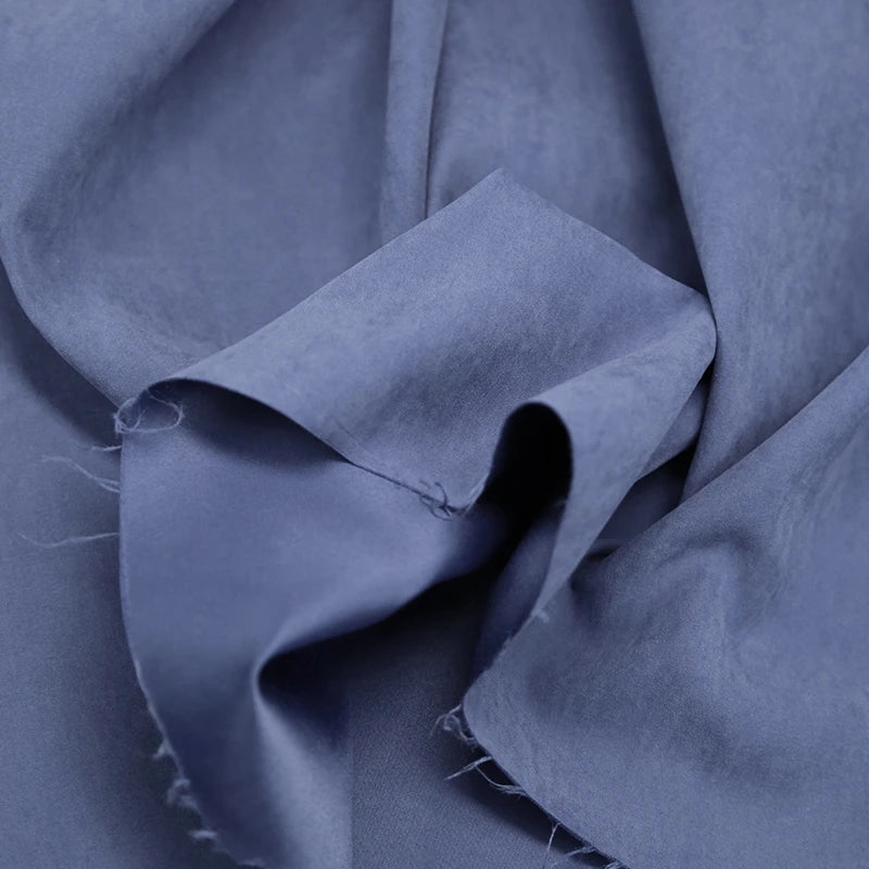 A close-up of Longan Craft Multi Color Microsuede Polyester Peachskin Fabric by the yard, showing its soft, brushed peach skin texture, gentle folds, and subtle details along the unfinished edges. Perfect cozy material for clothing.