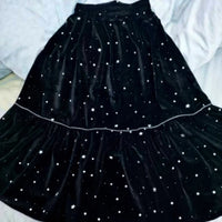 A black velvet skirt with tiered layers and white star prints inspires your next handmade look—perfect for the Women’s Pleated Midi Skirt Sewing Pattern by Longan Craft. Download the free PDF pattern to start sewing!.