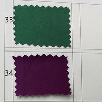 Two fabric swatches are displayed on a grid: Swatch 33 is green and Swatch 34 is purple, showing the vibrant hues of Longan Craft's Multicolor Satin Fabric By The Yard. Both silky polyester satin samples have zigzag-cut edges and numbered labels.
