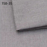 A close-up of two pieces of Longan Craft Faux Linen Upholstery Fabric in light gray polyester, featuring a subtle woven texture and one piece folded over the other. The code 158-35 is shown in black in the top left corner.