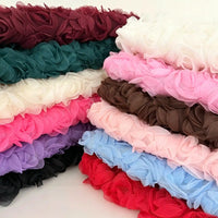 Stacks of Longan Craft 3D Blossom Roses Embroidered Tulle Fabric by the Yard, shown in burgundy, green, white, pink, brown, purple, blue, and red. Multicolor floral embroidery tulle material ideal for wedding or evening dresses. Displayed on a white background.