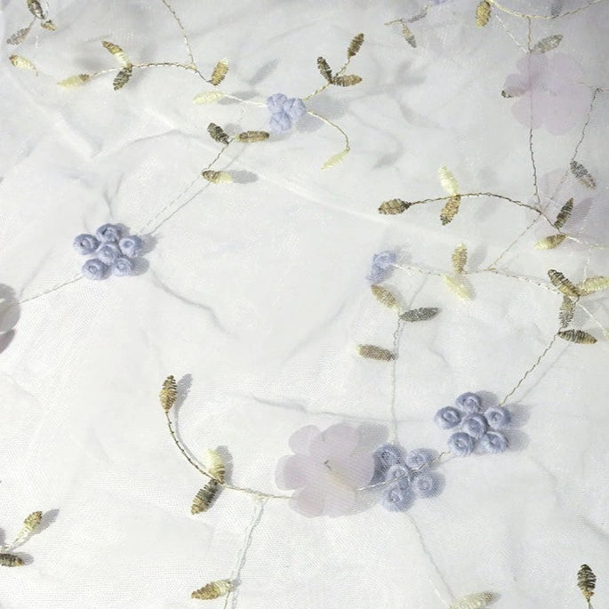 The 3D Floral Embroidered Tulle Fabric by Longan Craft features colorful botanical embroidery on sheer tulle, creating an elegant, airy pattern—ideal for bridal gowns and wedding dresses. Available by the yard.