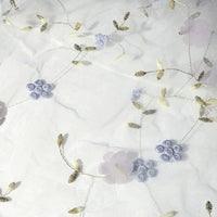 The 3D Floral Embroidered Tulle Fabric by Longan Craft features colorful botanical embroidery on sheer tulle, creating an elegant, airy pattern—ideal for bridal gowns and wedding dresses. Available by the yard.