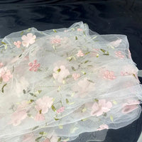 Longan Craft’s 3D Floral Embroidered Tulle Fabric by the yard features colorful botanical embroidery on white tulle, perfect for bridal gowns or special occasion dresses. This elegant material is ideal for unique and memorable creations.