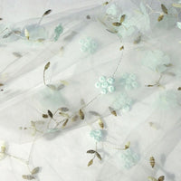 The 3D Floral Embroidered Tulle Fabric by Longan Craft features colorful botanical embroidery on airy tulle—ideal for bridal gowns, wedding dresses, and elegant creations. Available by the yard for your custom designs.