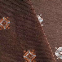 Close-up of Longan Craft 3D Patterned Embroidery Corduroy Fabric by the yard, featuring blue, orange, and white diamond embroidery on premium cotton fine wale corduroy. Folds highlight the detailed stitching and comfy texture.