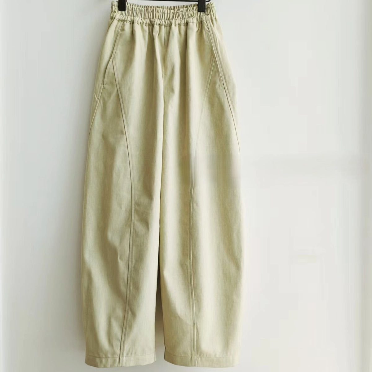 The Structured Pants Sewing Pattern by Longan Craft is a free PDF pattern download for light beige, loose-fitting, high-waisted tailored pants featuring an elastic waistband, wide legs, and side seam pockets shown against a white background.