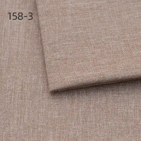 A close-up of Longan Craft's Faux Linen Upholstery Fabric by the yard shows light brown polyester with a subtle texture, plus a folded piece on top. The number 158-3 appears in the upper left corner.