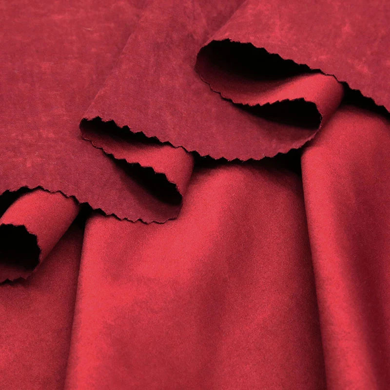 Close-up of Longan Craft Multi Color Microsuede Polyester Peachskin Fabric, showing zigzag-cut deep red pieces with a smooth, shiny front and soft, brushed peachskin back—ideal for cozy clothing and sold by the yard.