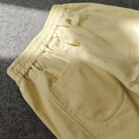 Structured pants made with the Longan Craft Structured Pants Sewing Pattern (free PDF download) shown in light yellow, featuring an elastic waistband and side pockets—ideal for your next high-waisted tailored pants project.