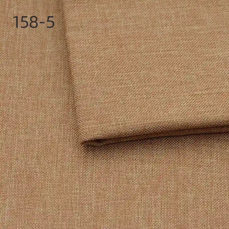 Close-up of Longan Craft Faux Linen Upholstery Fabric in light brown, with one piece folded over another. The number 158-5 is printed in the top left corner. Ideal polyester fabric for reupholstering furniture, chairs, sofas, or curtains.