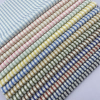 Neatly arranged Vintage Plaid Seersucker Fabric by the Yard from Longan Craft, featuring a polyester-cotton blend and small checkered pastel and muted patterns, ideal for DIY dresses, shirts, and bags.