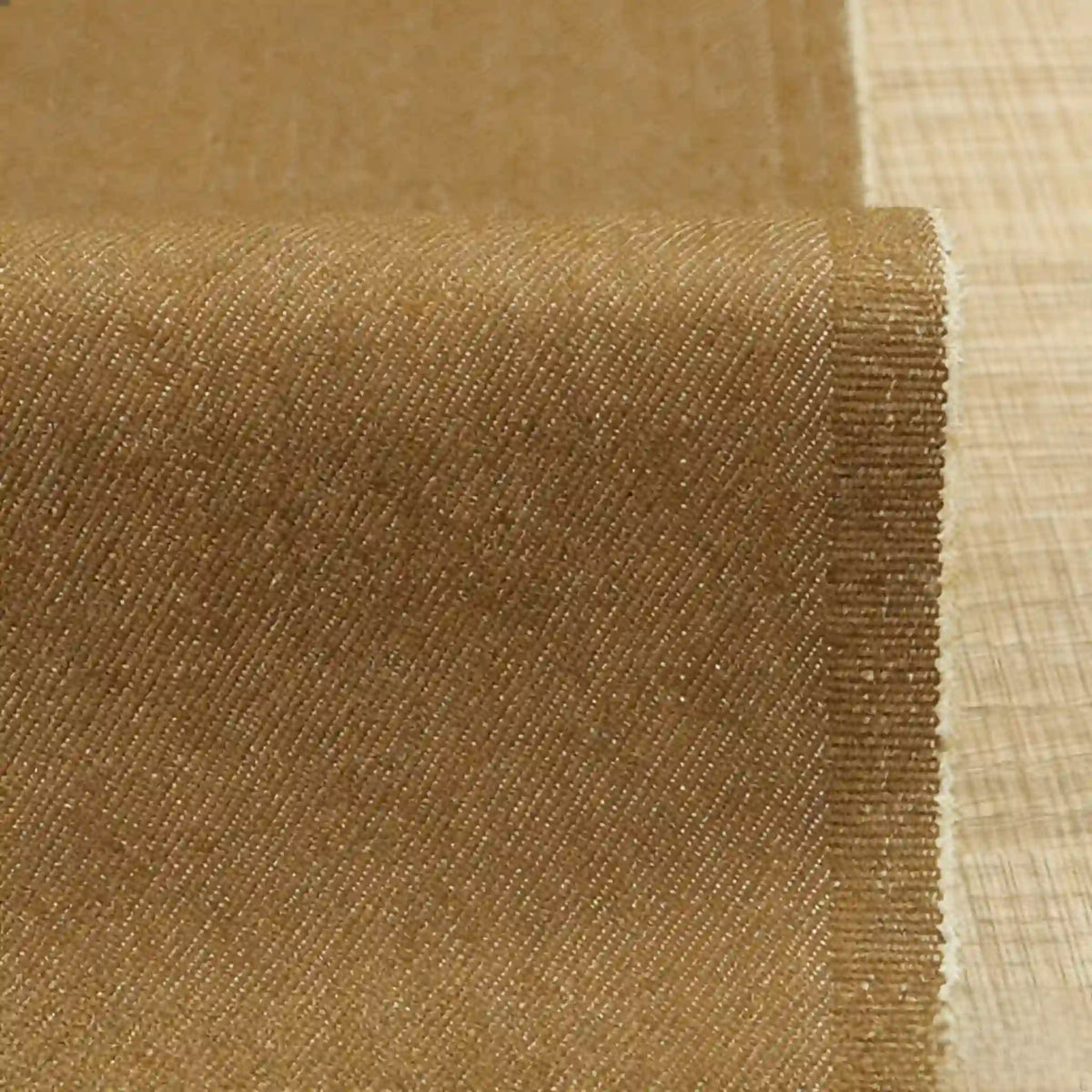 A close-up of Longan Craft's 9.5oz Stretch Denim Fabric in light brown, showing its subtle diagonal pattern and soft, medium-weight cotton material—ideal for jeans and other denim projects. Available by the yard.