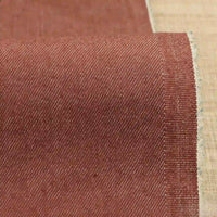A close-up of Longan Craft's 9.5oz Stretch Denim Fabric by the yard shows its solid reddish-brown color, medium weight, and fine diagonal weave—ideal cotton denim material for jeans and more.