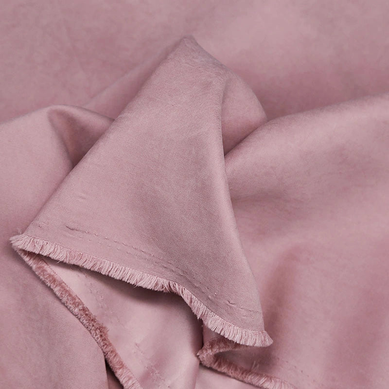 A close-up of Longan Craft’s Multi Color Microsuede Polyester Peachskin Fabric by the yard, featuring a smooth, brushed peach skin texture and soft, cozy material—perfect for clothing—folded casually against a matching background.