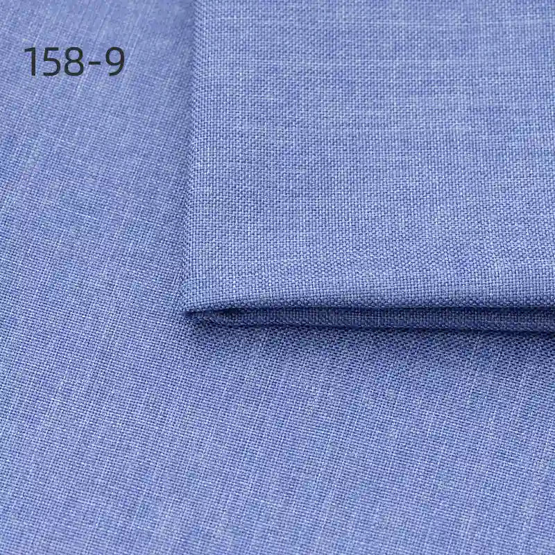 A close-up of Longan Craft Faux Linen Upholstery Fabric (158-9), light blue polyester with a subtle crosshatch texture. One folded piece rests atop another, showcasing this durable fabric for reupholstering furniture and curtains.