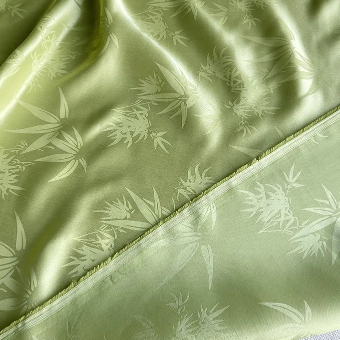 Longan Craft's Bamboo Jacquard Mulberry Silk Fabric By The Yard features a smooth, shiny texture, colorful floral and leaf patterns, and slightly frayed edges—ideal for cozy silk lining or creative projects.