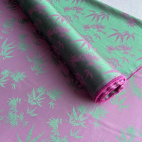 The Bamboo Jacquard Mulberry Silk Fabric by Longan Craft features a purple and green gradient with green bamboo leaves, made from a soft, slightly shiny mulberry silk blend—ideal as colorful rayon silk fabric or cozy silk lining.