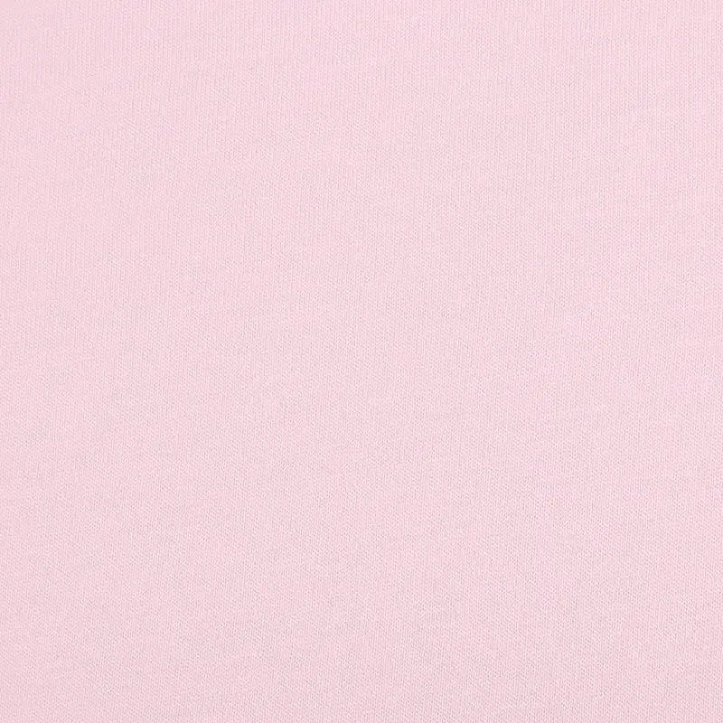 A close-up of Longan Craft’s Bamboo Jersey Fabric By The Yard showcases its light pink, smooth, and finely textured surface—an eco-friendly, plain elastane jersey perfect for loungewear with no visible patterns or designs.