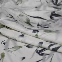 Close-up of Longan Craft's Bamboo Printed Nylon Viscose Fabric By The Yard, featuring a chinoiserie-inspired abstract floral print in green, black, and gray on lightweight eco-friendly viscose, softly draped with gentle folds.