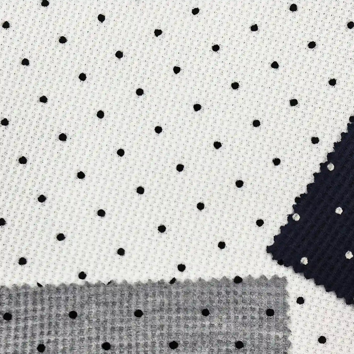 Black Mini Polka Dot Print Waffle Fabric By The Yard in a white waffle-knit, shown with small swatches of navy and grey textured fabric.