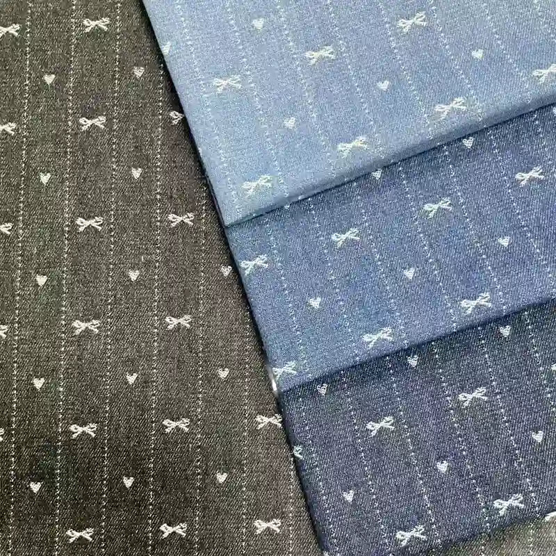 Four pieces of Longan Craft Bow Heart Jacquard Denim Fabric by the yard in blue and black, each with soft, washed cotton and neat vertical stripes featuring charming white bow and heart motifs—ideal for pants or crafts.