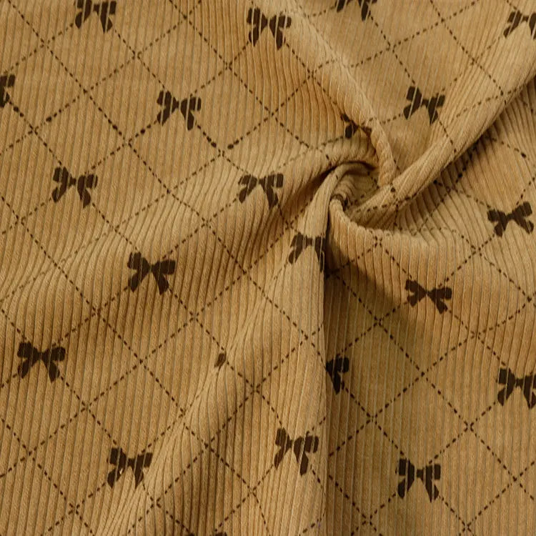 The Longan craft Bow Plaid Print Corduroy Fabric By The Yard is a heavyweight, soft, and durable corduroy material featuring a diamond grid checked pattern accented with small, dark brown bows at each intersection. This printed fabric gathers beautifully at the center, showcasing its cozy texture and gentle folds—ideal for creating comfortable and stylish clothing.
